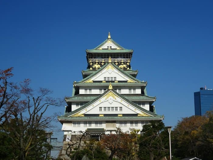 A castle keep with green roofs and white walls against a blue sky