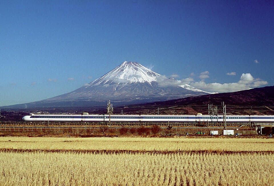 Snow-capped Mount Fuji with a Series 0 Shinkansen running in front. Photographed in 1999